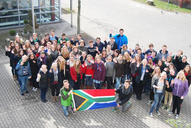 Gruppe Schüler und Mitarbeiter mit südafrikanischer Flagge