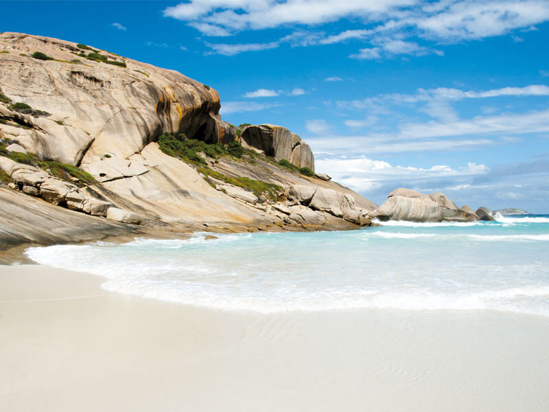 Australischer Küstenstrand mit zerklüfteten Felsen und blauem Meer